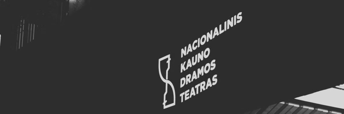 Illuminated signage of Kaunas Drama Theatre in black and white low angle shot.